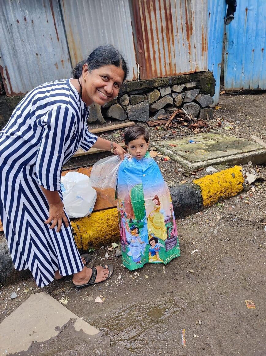 A child receiving a raincoat from Dira Foundation for their school commute