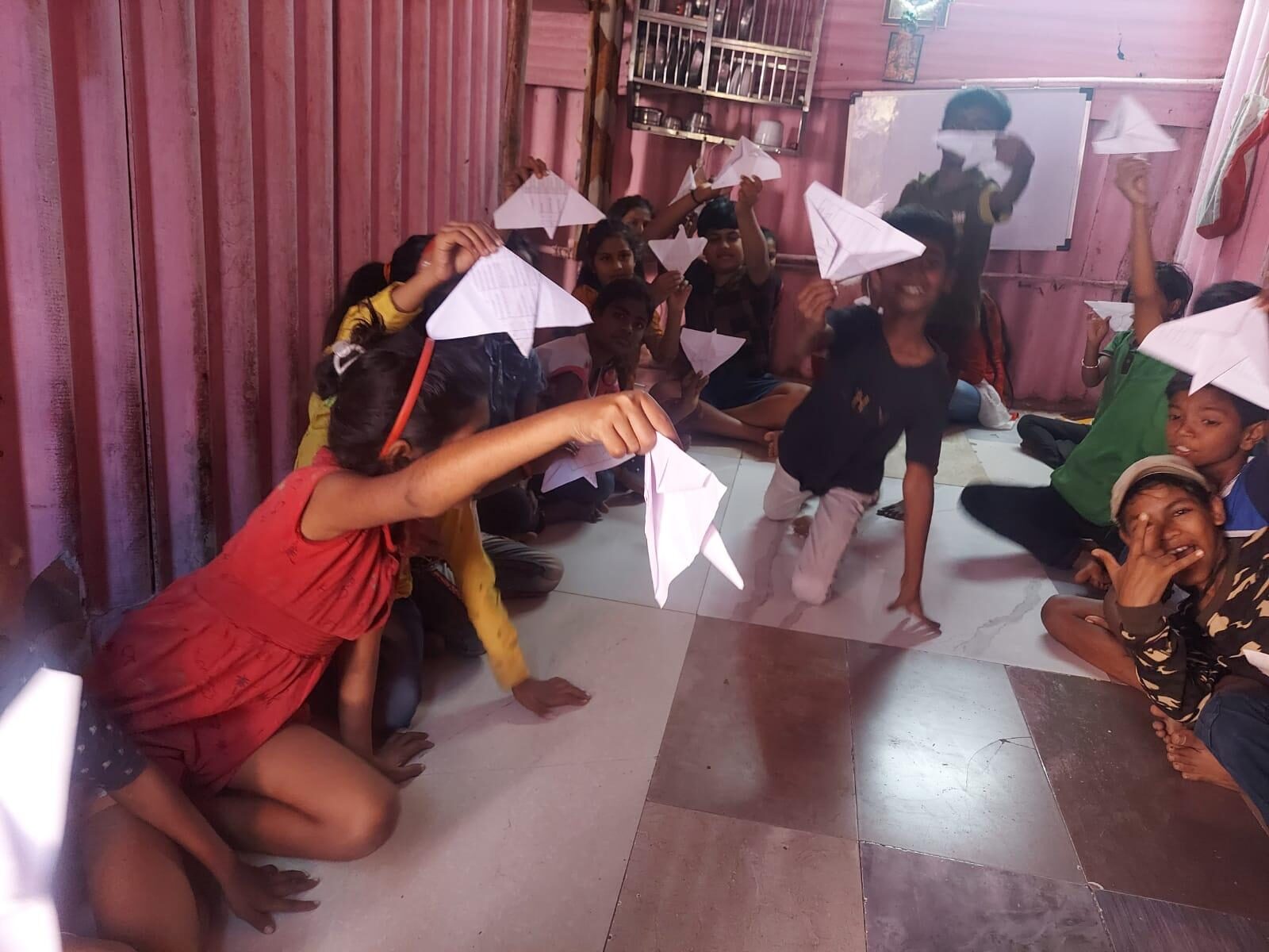 Children playing with paper planes during a craft activity